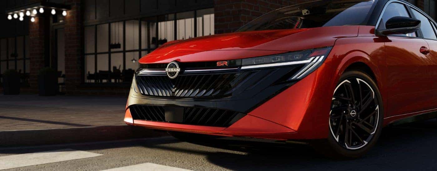 Front grille of a red 2026 Nissan Sentra SR parked at night.