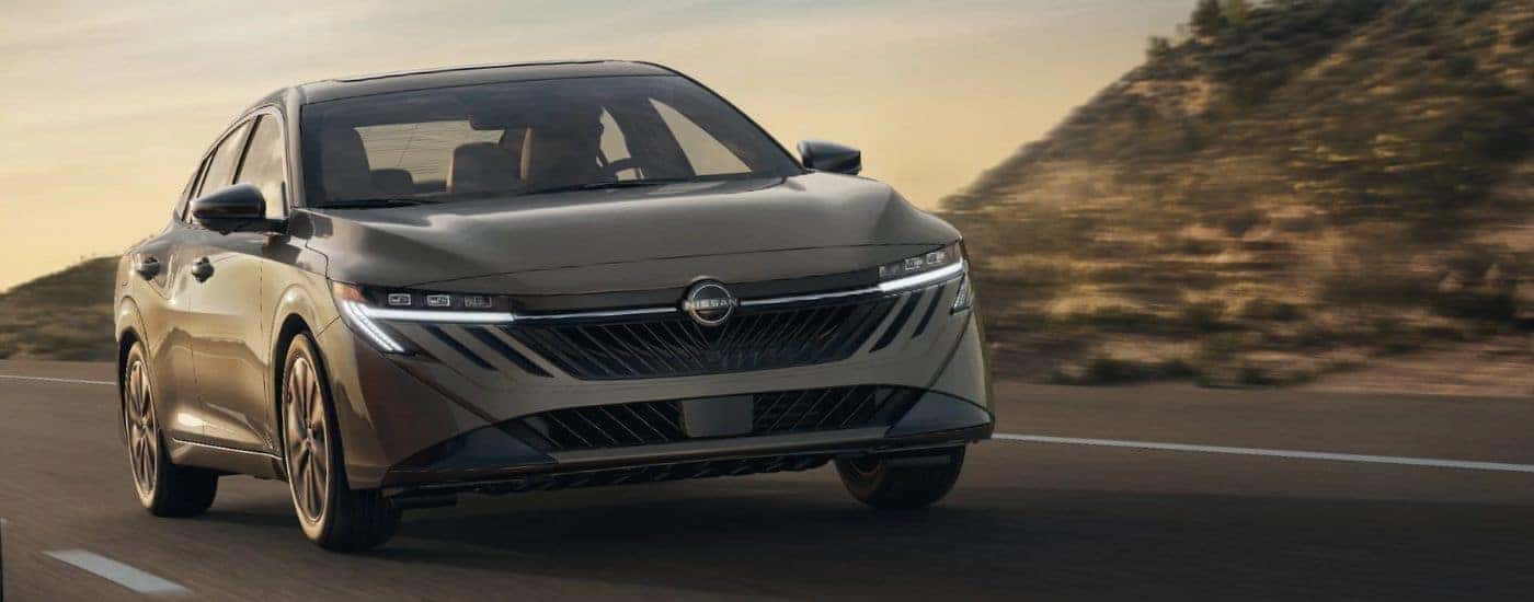 Front view of a tan 2026 Nissan Sentra driving.