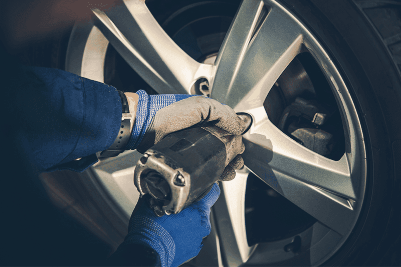 technician installs new car tire
