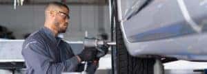 certified technician removes bolts from car tire
