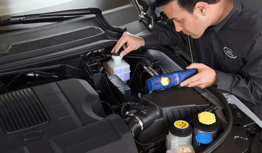 Land Rover service technician working under the hood of a vehicle