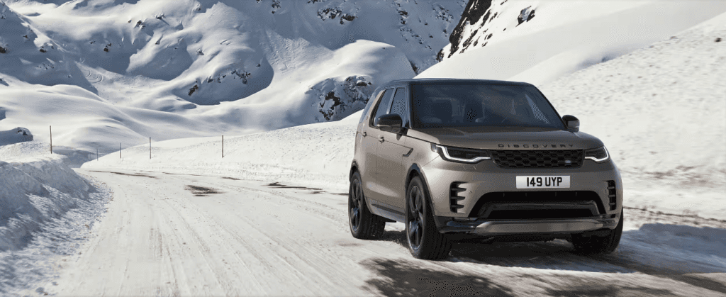 2024 Discovery on a snowy road with mountains in the background