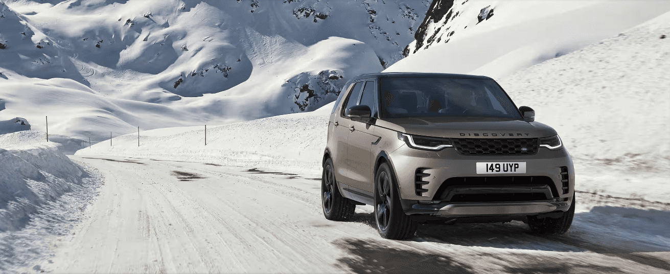 2024 Discovery on a snowy road with mountains in the background