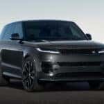 A black Range Rover Sport driving down the road in a flat area.
