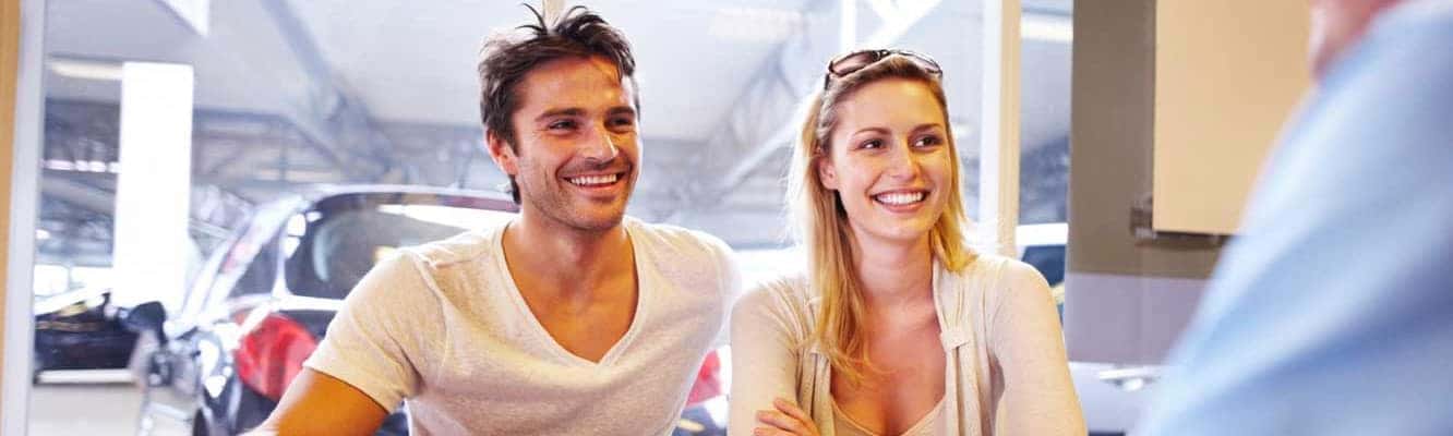 smiling couple signing up for Legacy Toyota Advantage