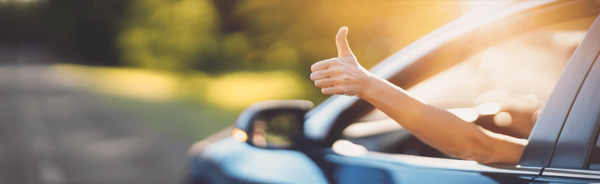 Hand with a thumbs up sticking out of a car window. Stay safe in a 2024 Nissan Altima.
