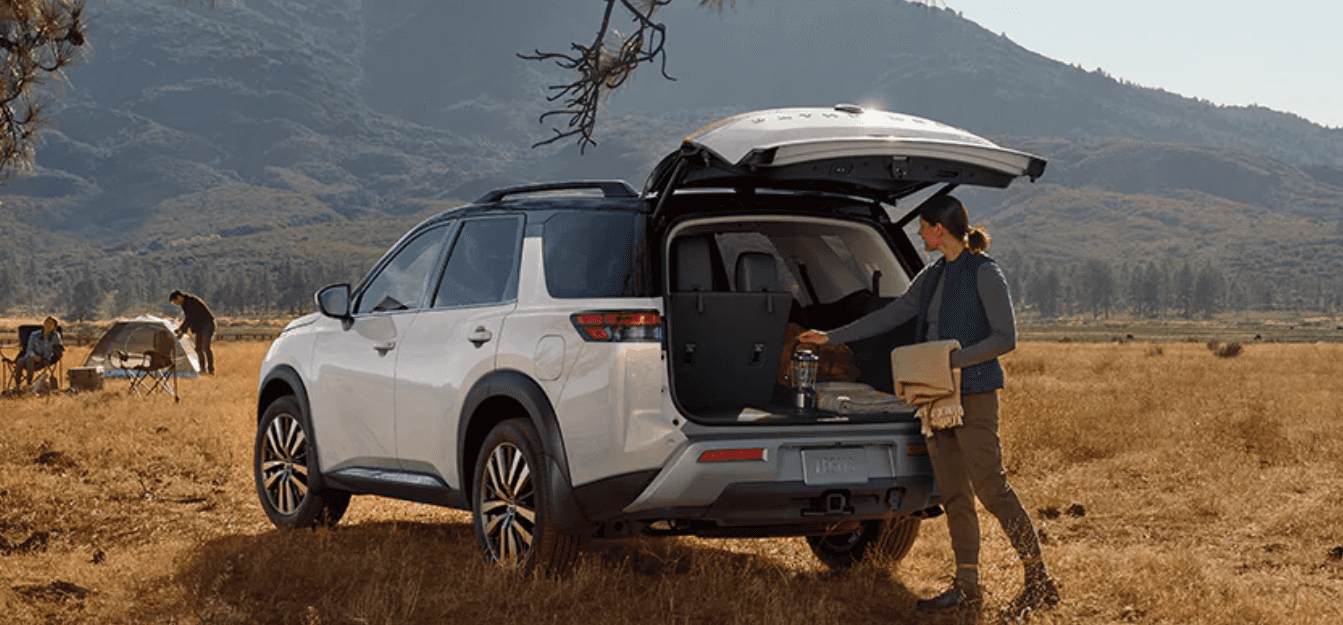 A woman taking things from the rear cargo area of a white 2024 Nissan Pathfinder