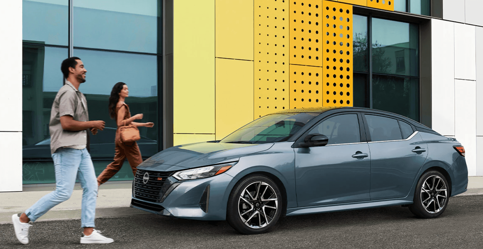 Two people approaching a parked 2025 Nissan Sentra