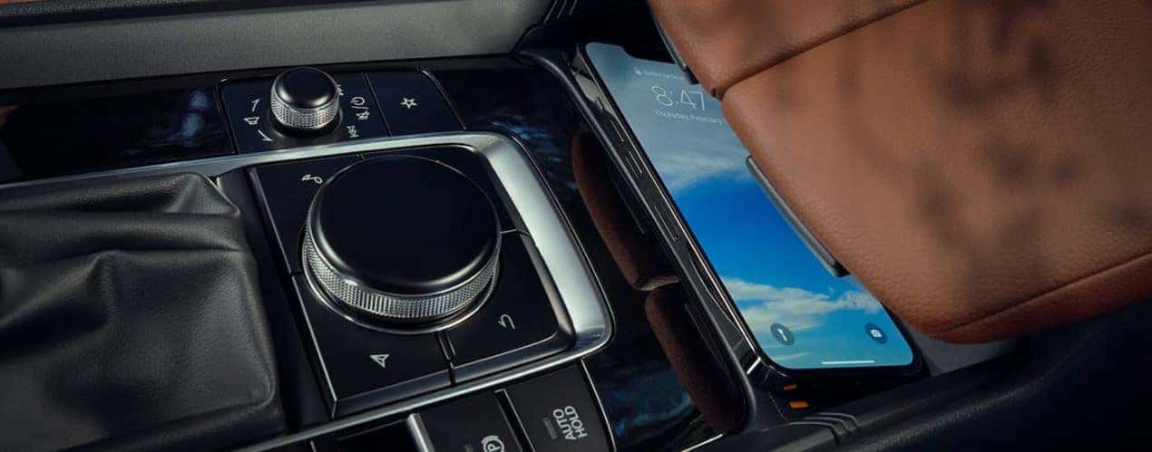 A close up shows a cell phone wirelessly charging in a 2023 Mazda CX-50.