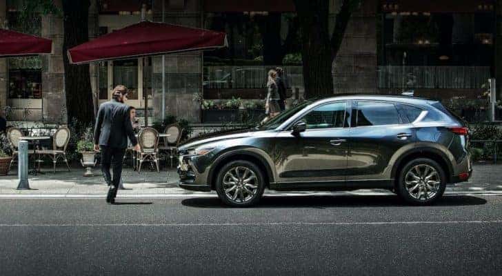 A grey 2021 Mazda CX-5 is shown from the side on a city street after visiting an Irmo Mazda dealer.