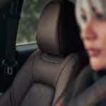 A close up shows the leather passenger seat and driver in a 2022 Mazda CX-5.