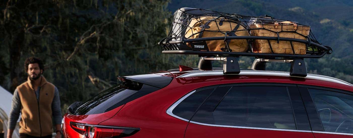 A close up shows a roof rack, basket, and luggage on a red 2022 Mazda CX-30.