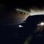 A black 2024 Mazda CX-90 for sale is shown driving through a tunnel.