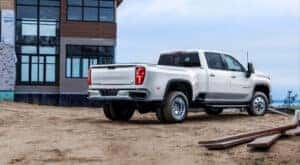 A white 2024 Chevy Silverado 3500 HD LTZ is shown from the rear on a construction site.