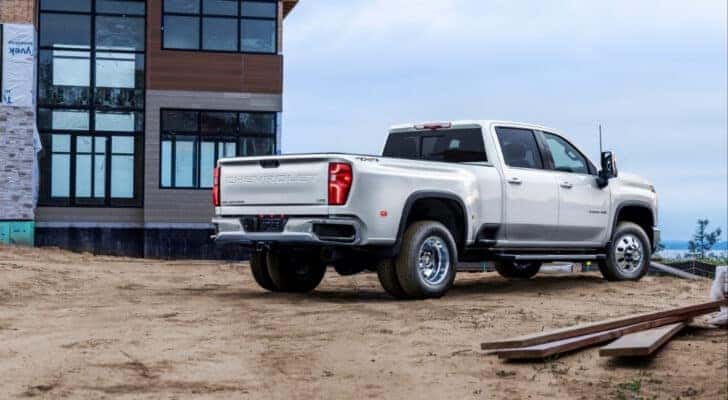 A white 2024 Chevy Silverado 3500 HD LTZ is shown from the rear on a construction site.