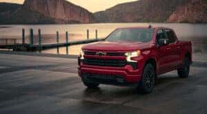 A red 2024 Chevy Silverado RST Z71 parked by a lake.