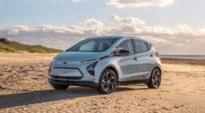A blue 2022 Chevy Bolt EV is shown parked on a beach after leaving a Chevy dealer near you.