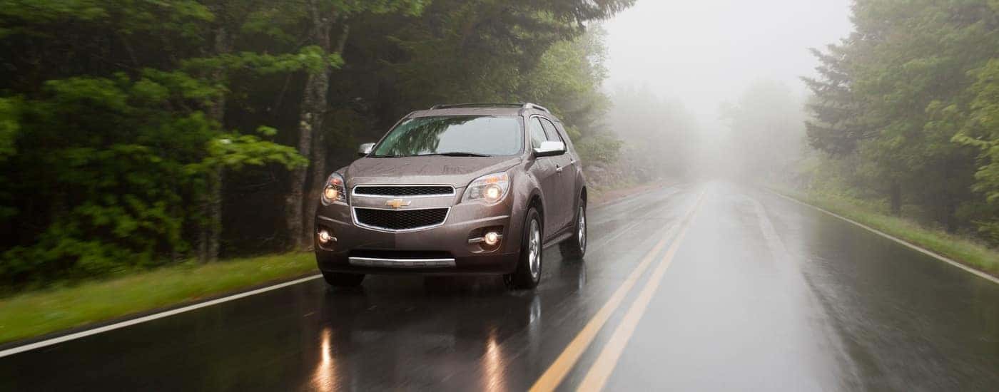 A tan 2012 Chevy Equinox LTZ is shown driving on a foggy day.