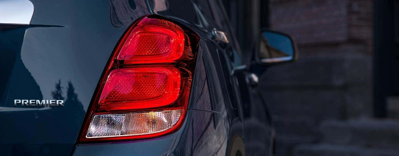 A close-up shows the passenger side taillight on a dark blue 2020 Chevy Trax Premier.