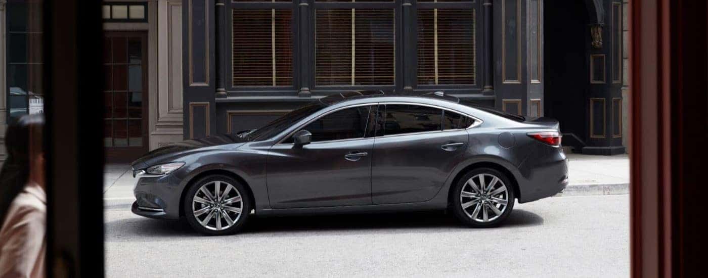 A gray 2019 Mazda6 is shown parked on a city street.