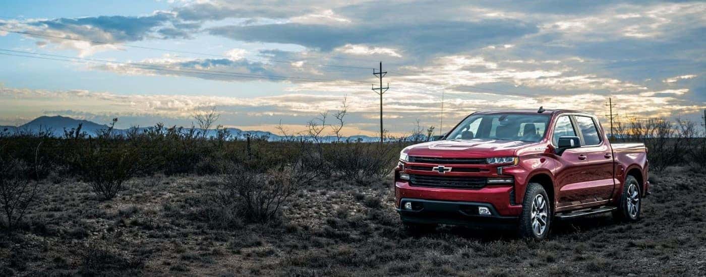 A red 2023 Chevy Silverado 1500 RST is shown parked on a cloudy day.