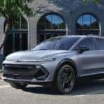 A gray 2025 Chevy Equinox EV RS is shown parked on a parking spot.