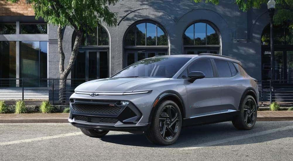 A gray 2025 Chevy Equinox EV RS is shown parked on a parking spot.