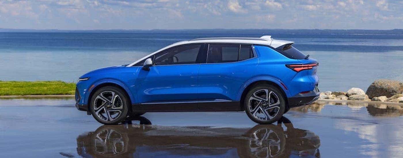 A blue 2024 chevy Equinox EV for sale is shown from the side.