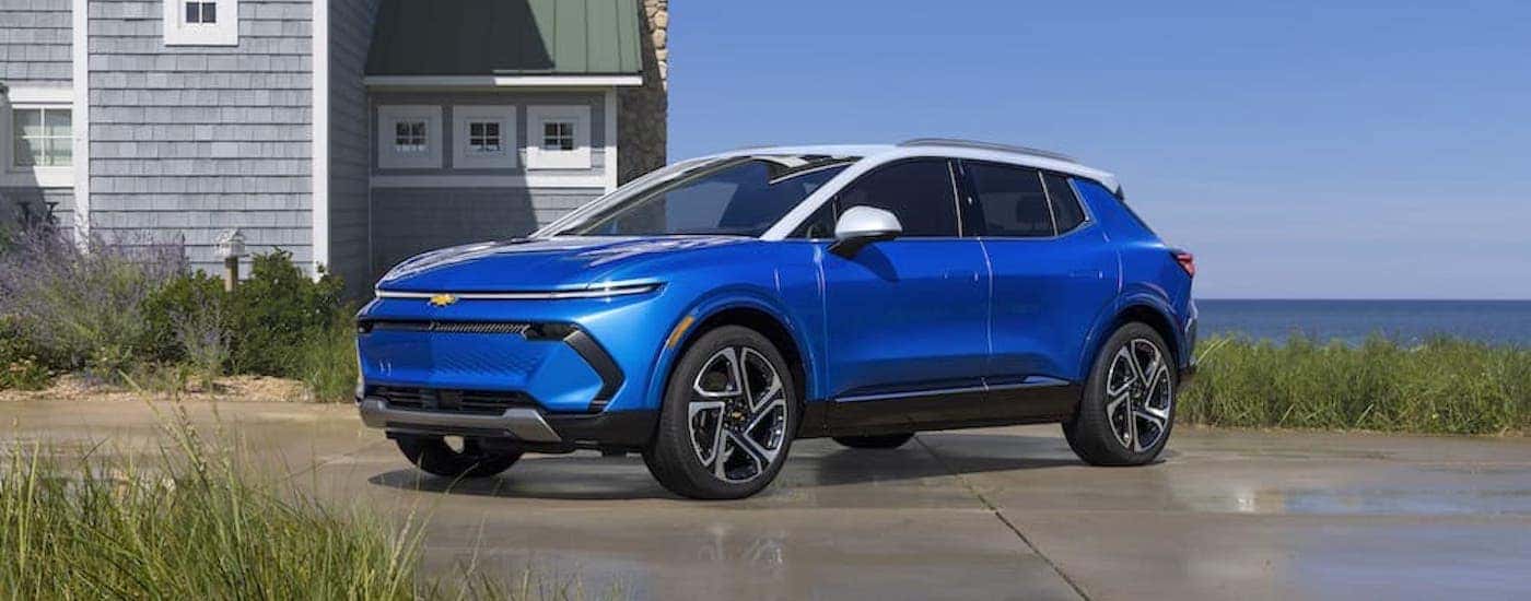 A blue 2024 Chevy Equinox EV is shown from the front at an angle after leaving a dealer that has used EVs for sale.