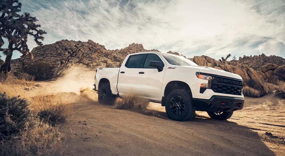 A white 2024 Chevy Silverado for sale from the side.