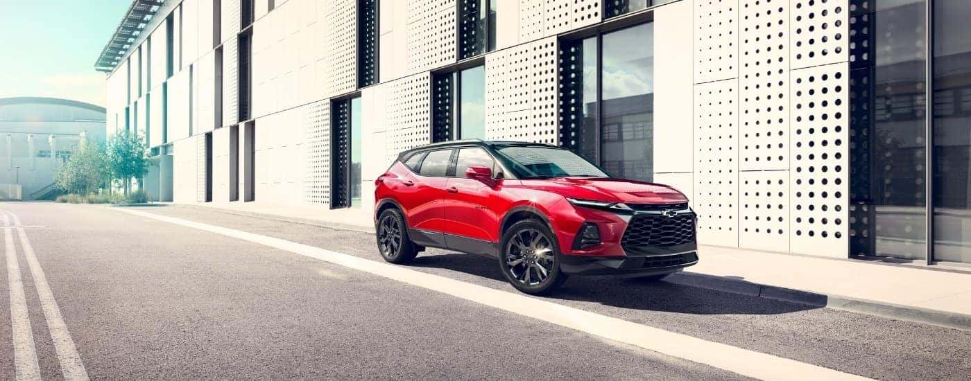 A red 2025 Chevy Blazer RS in a city street.