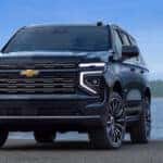 A black 2025 Chevy Tahoe for sale parked near a lake.