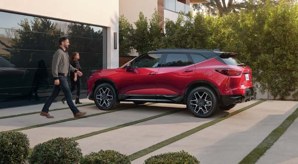 A red 2025 Chevy Blazer for sale is parked on a driveway.