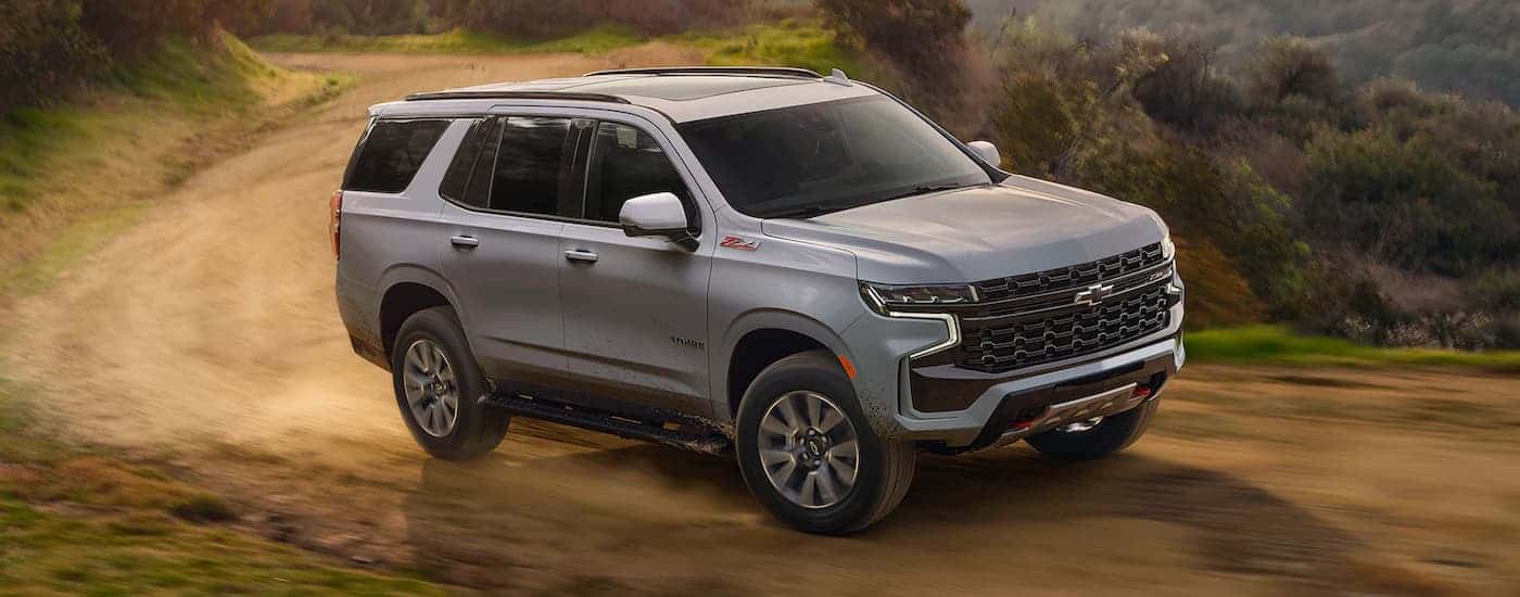 A dark grey 2024 Chevy Tahoe Z71 driving down a trail.