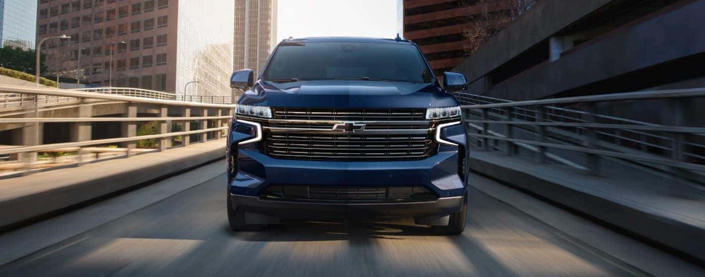 Front of a blue 2023 Chevy Tahoe for sale near Mooresville driving over a bridge.