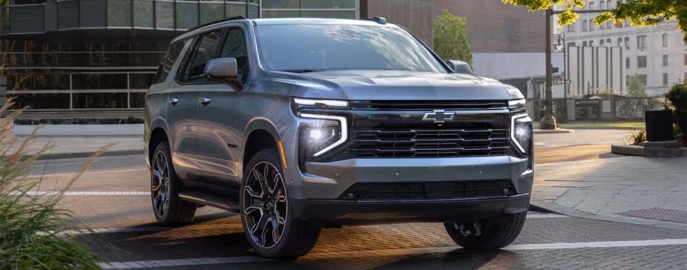 Grey 2025 Chevy Tahoe driving through a city.