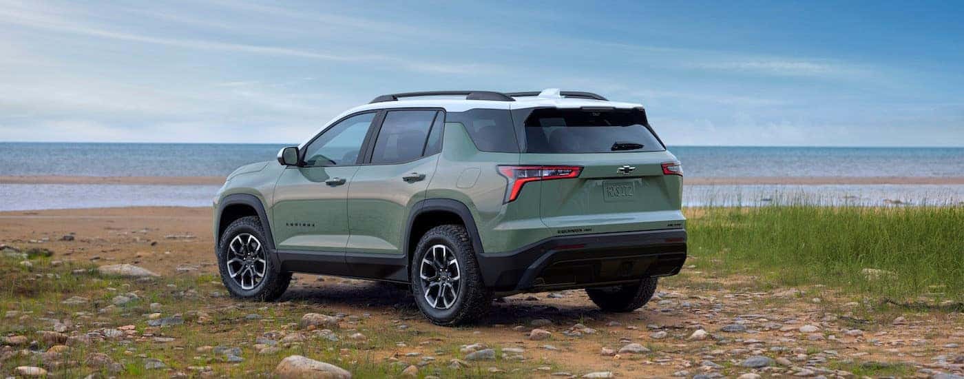 A green 2025 Chevy Equinox for sale near Concord from the rear at an angle.