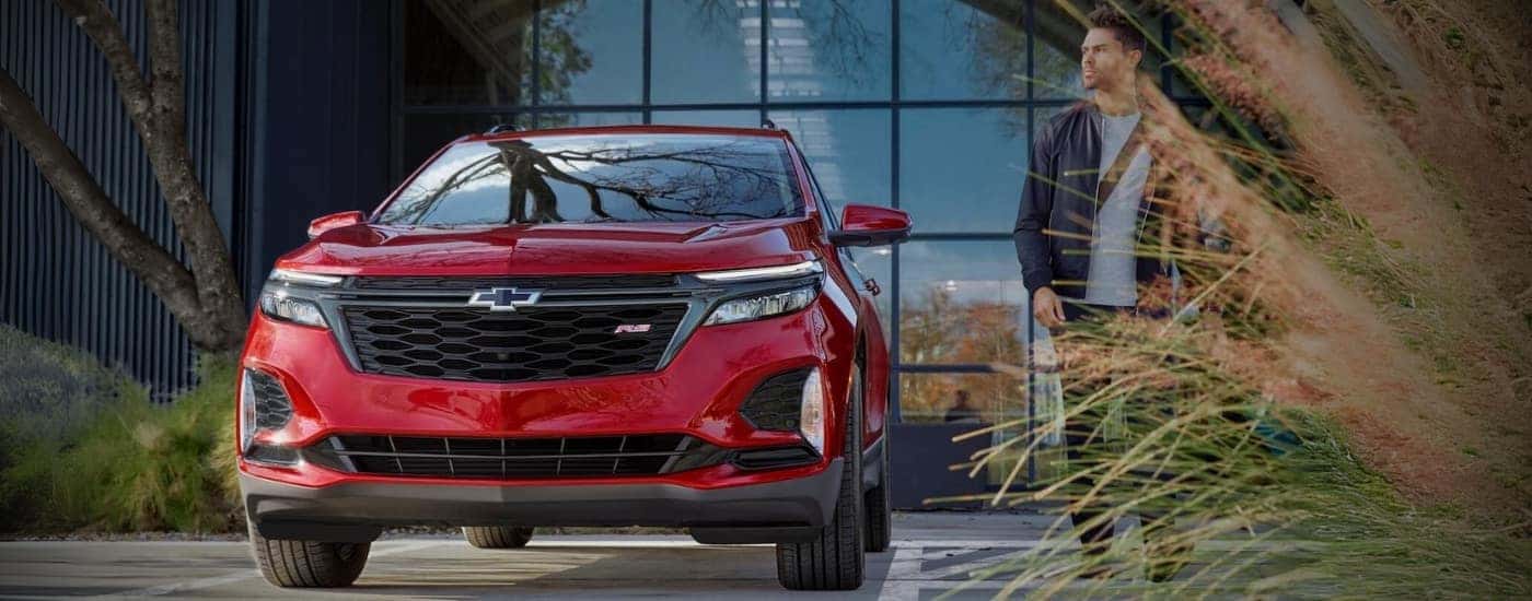 A red 2024 Chevy Equinox for sale near Kannapolis parked near a building.