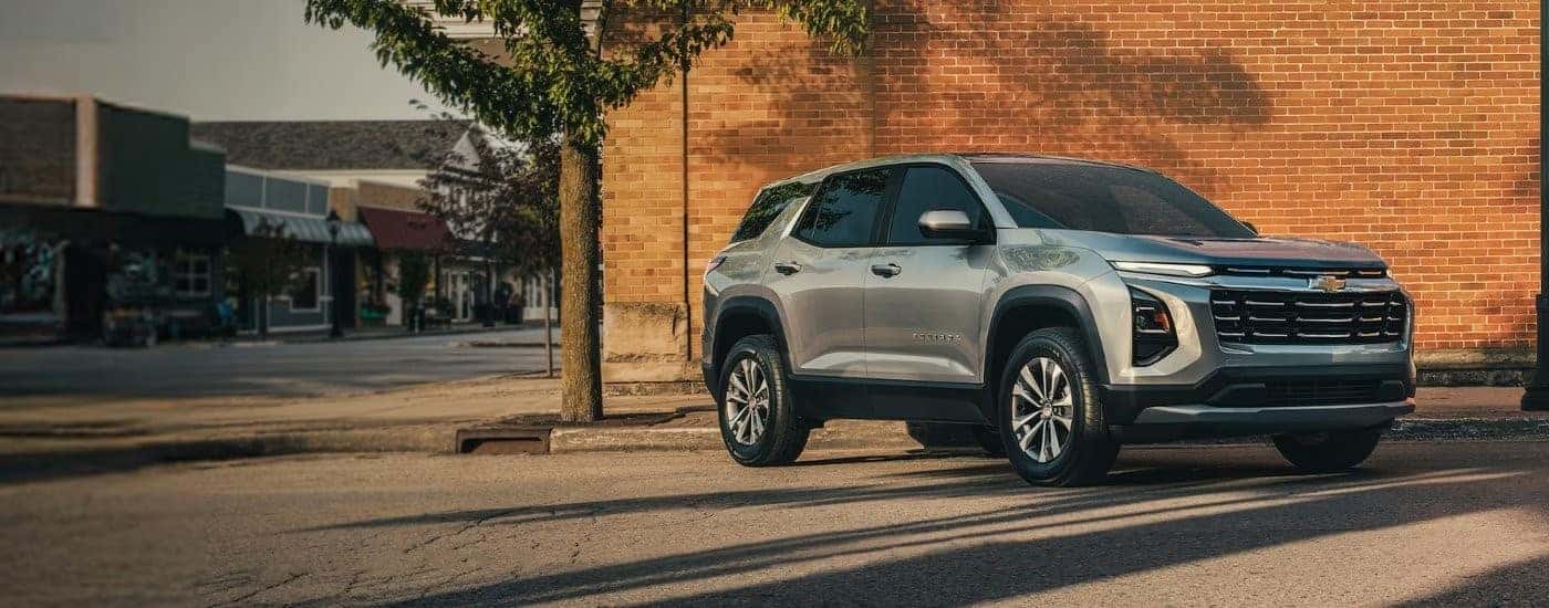 A silver Chevy Equinox for sale near Statesville parked in front of a brick building.