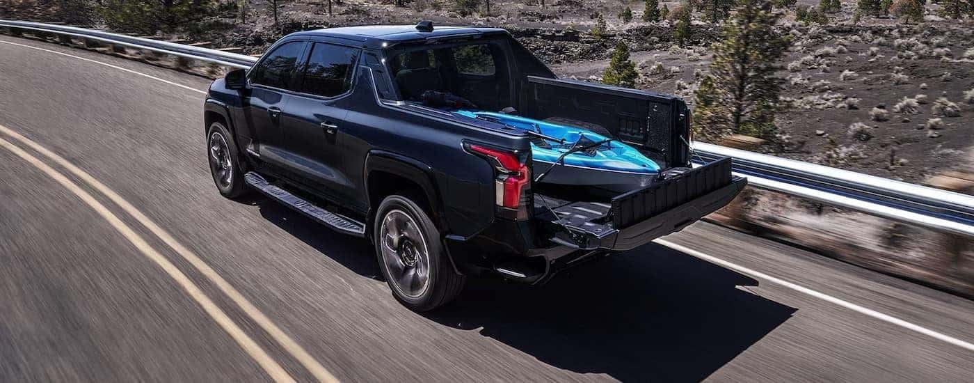 A black 2025 Chevy Silverado EV for sale near Concord from the rear at an angle.