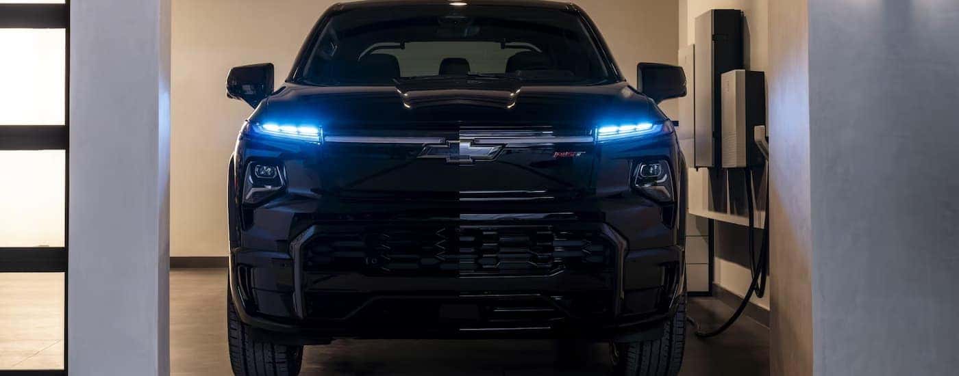A black 2025 Chevy Silverado EV charging in a garage