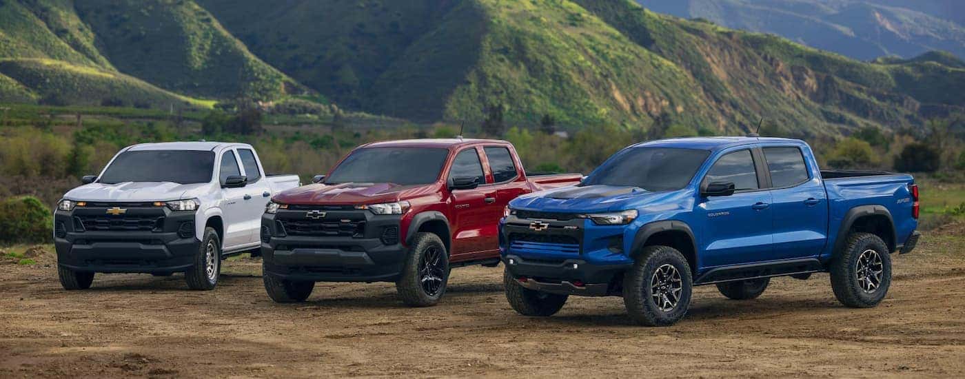 Three 2025 Chevy Colorado parked off-road on sand