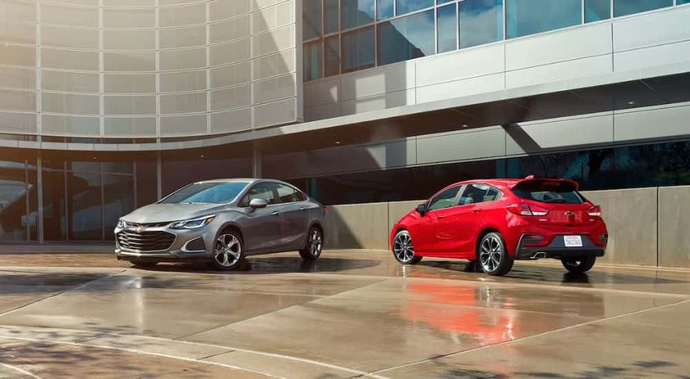 A red and silver used 2019 Chevy Cruze parked outside a building