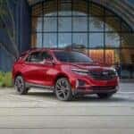 A red used 2024 Chevy Equinox RS parked outside a building for sale