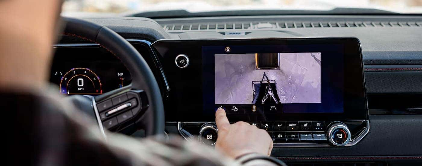 A man using the touch screen infotainment display in a 2025 Chevy Colorado