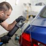 Man polishing up a car in a car paint shop