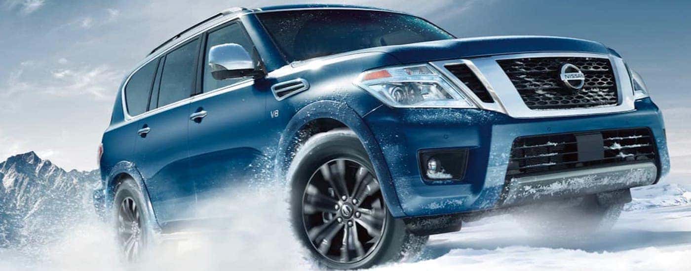 A blue 2020 Nissan Armada is driving in the snow.