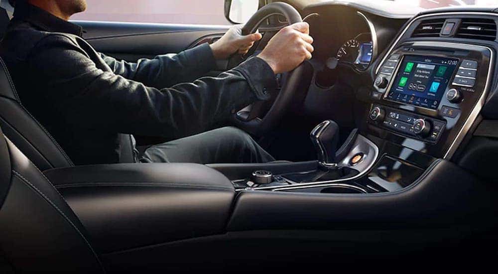 A man is shown driving a 2021 Nissan Maxima from the passenger seat after leaving a Chicagoland Nissan Dealer.
