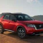 A red 2022 Nissan Pathfinder is parked on a mountain after leaving Joliet car dealers.