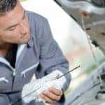 A mechanic is checking the oil level during a Nissan maintenance.